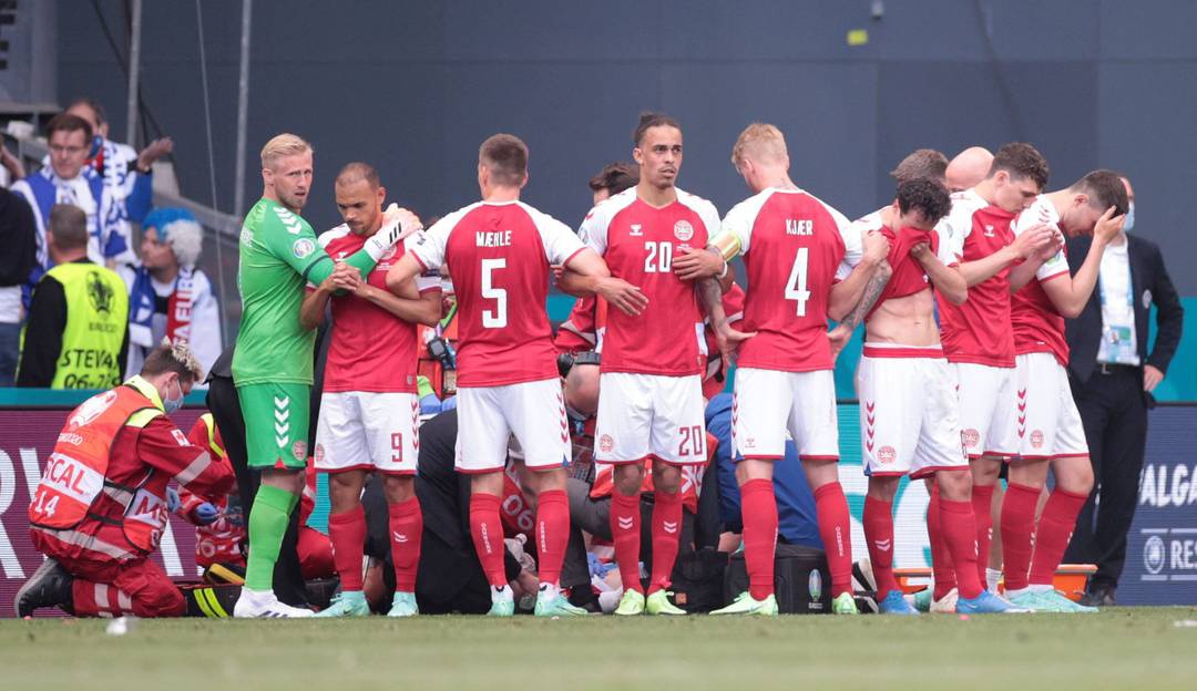 Cinturão humano dos jogadores da Dinamarca ao redor de Eriksen, enquanto meia era atendido